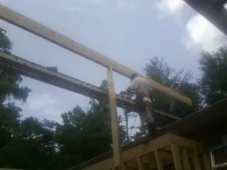 Carpenter setting a ridge beam over a new addition frame — Ice Dam Removal by Roofing Brothers in Arkadelphia