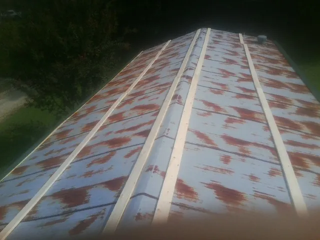 Rusted metal roof panels with new wood purlins before replacement — Storm Damage Roof Repair in Arkadelphia by Roofing Brothers