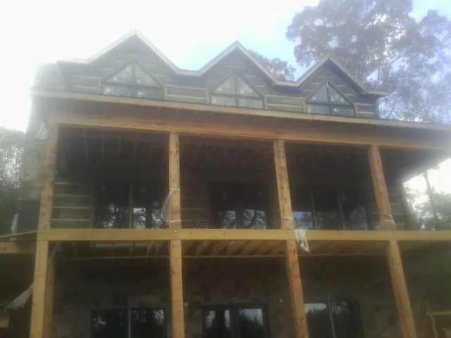Dormers and porch framing on a large log home under construction — Roof Coating work by our crew in Arkadelphia