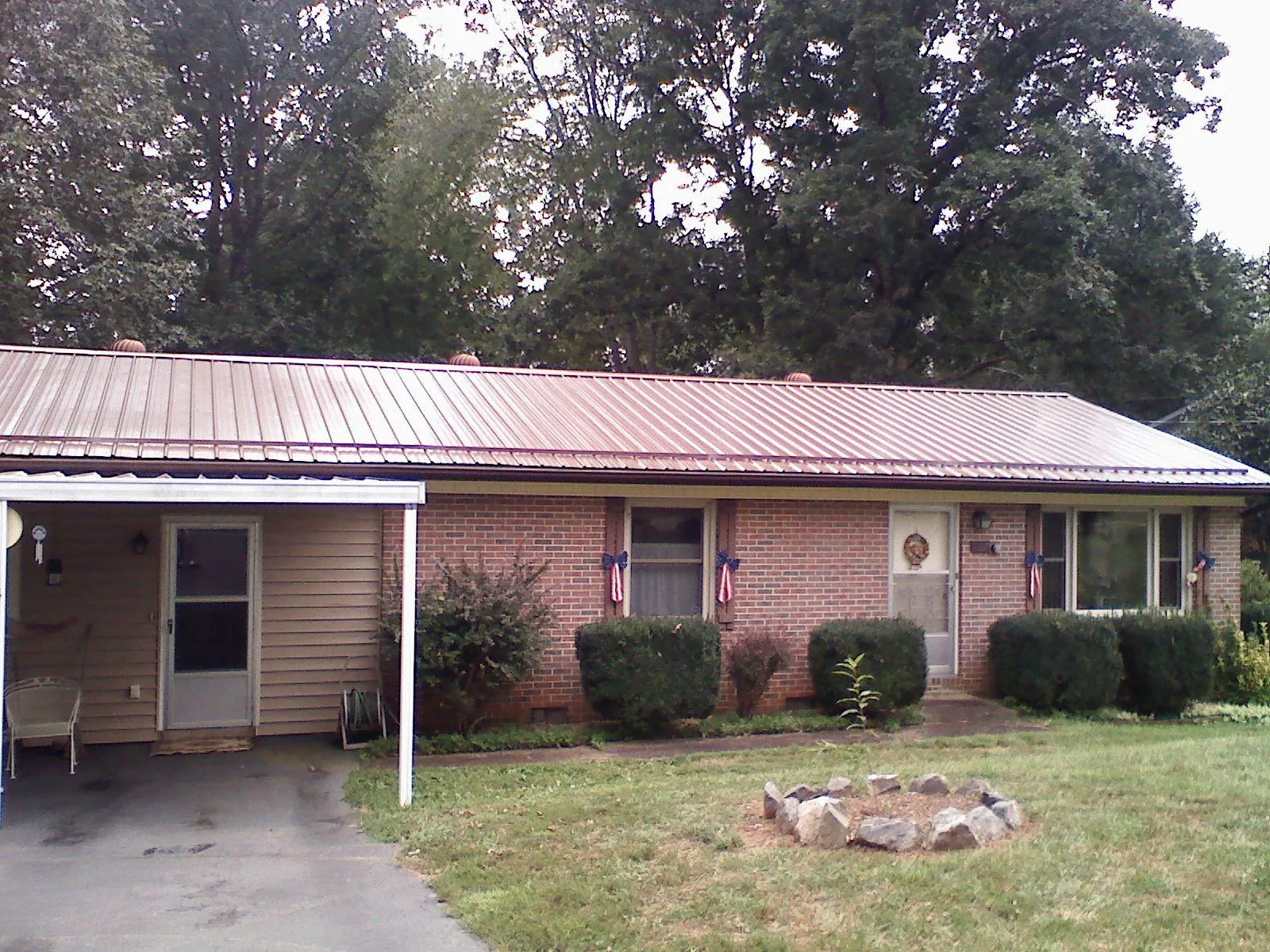 Bronze metal roof and carport on a brick ranch home — Roof Repair work by our crew in Arkadelphia
