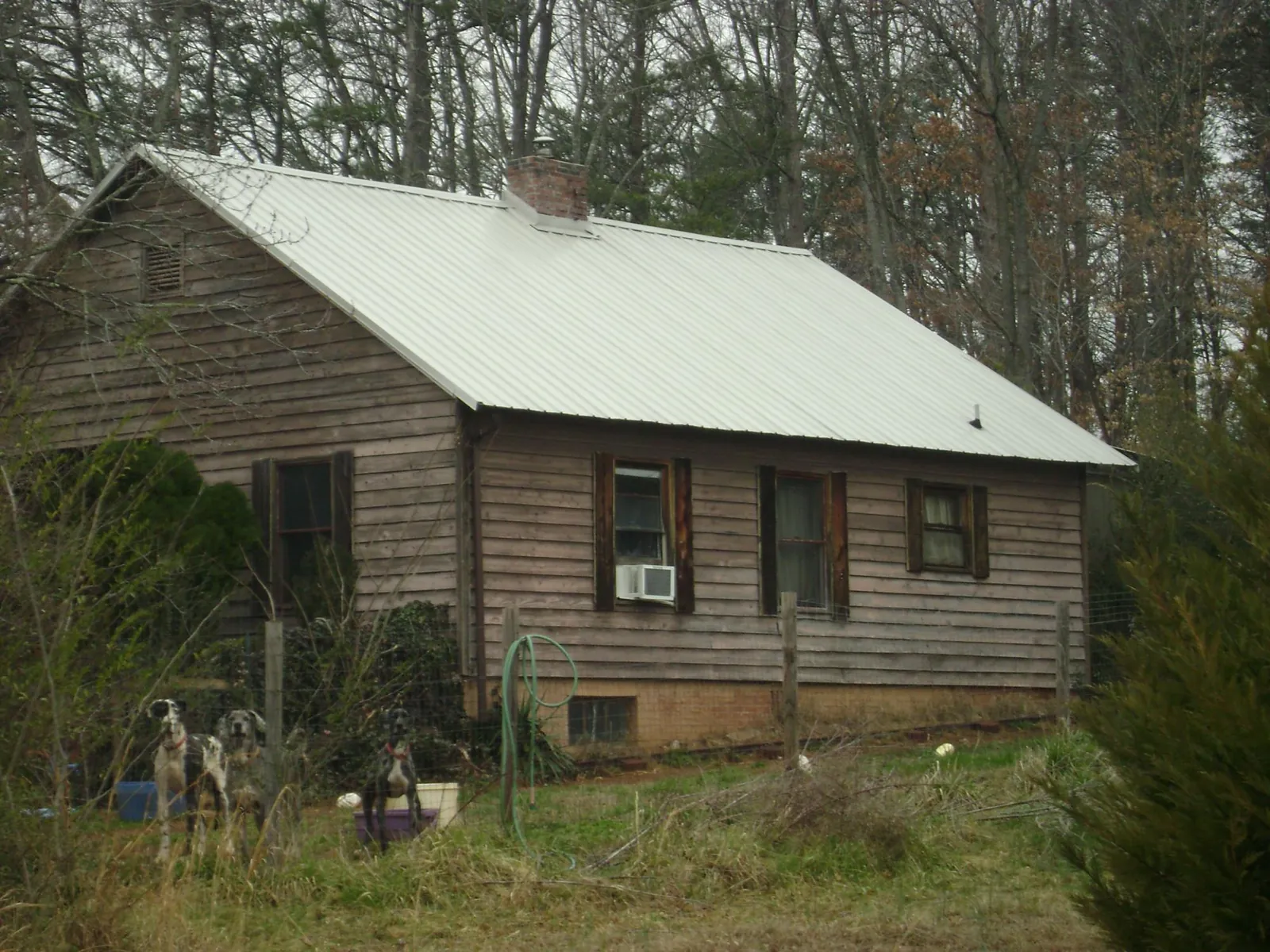 White metal roof on an old wood sided farmhouse, from a Metal Roof Installation job in Arkadelphia